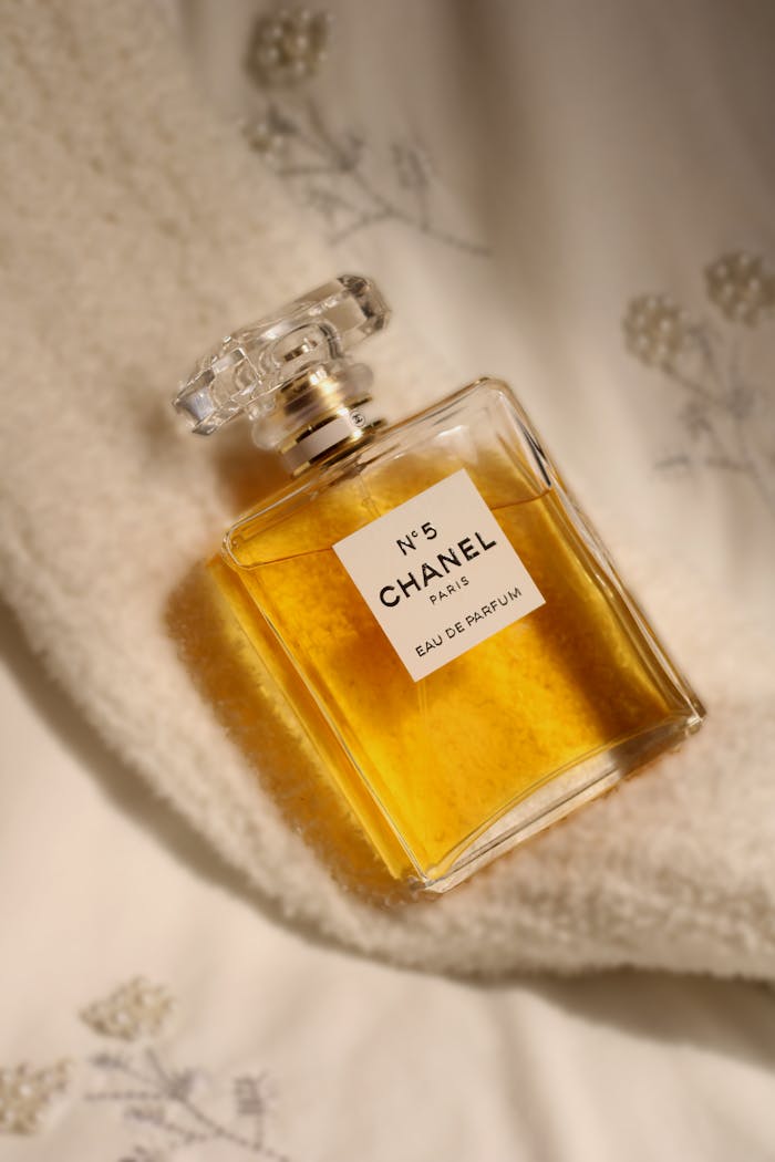 Elegant Chanel No. 5 perfume bottle resting on cozy fabric, epitomizing luxury.